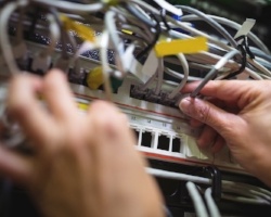 Technician plugging patch cable in a rack mounted server in server room-189997-edited.jpeg
